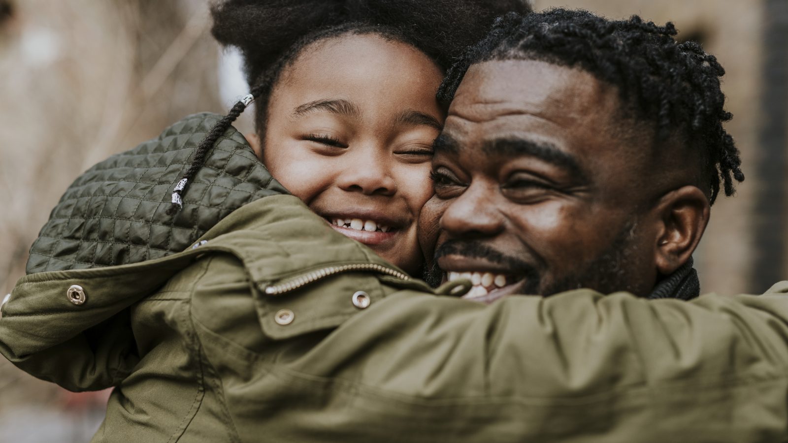 A father and his daughter holding on to each other, eyes closed